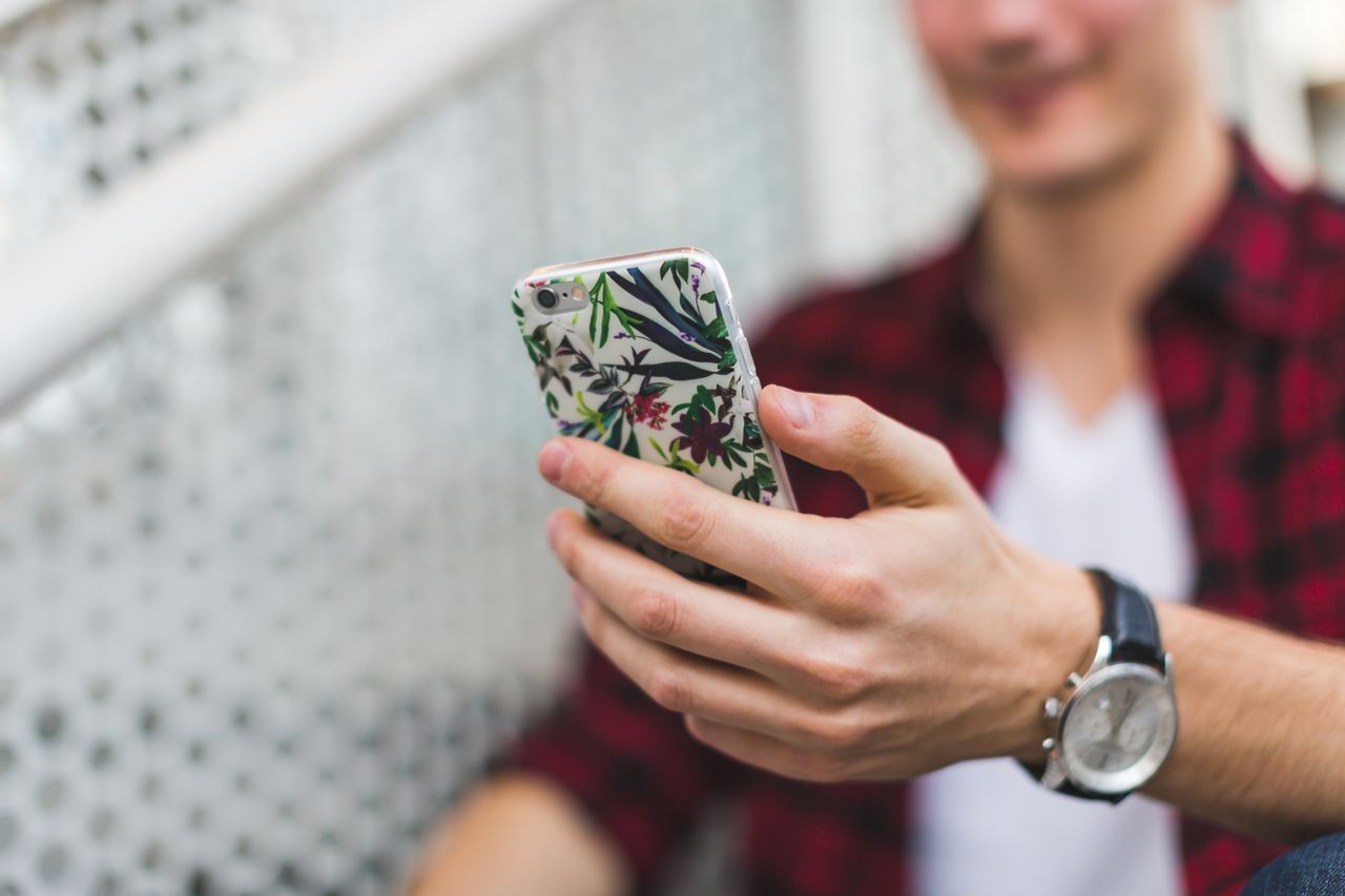 Person holding phone with floral case